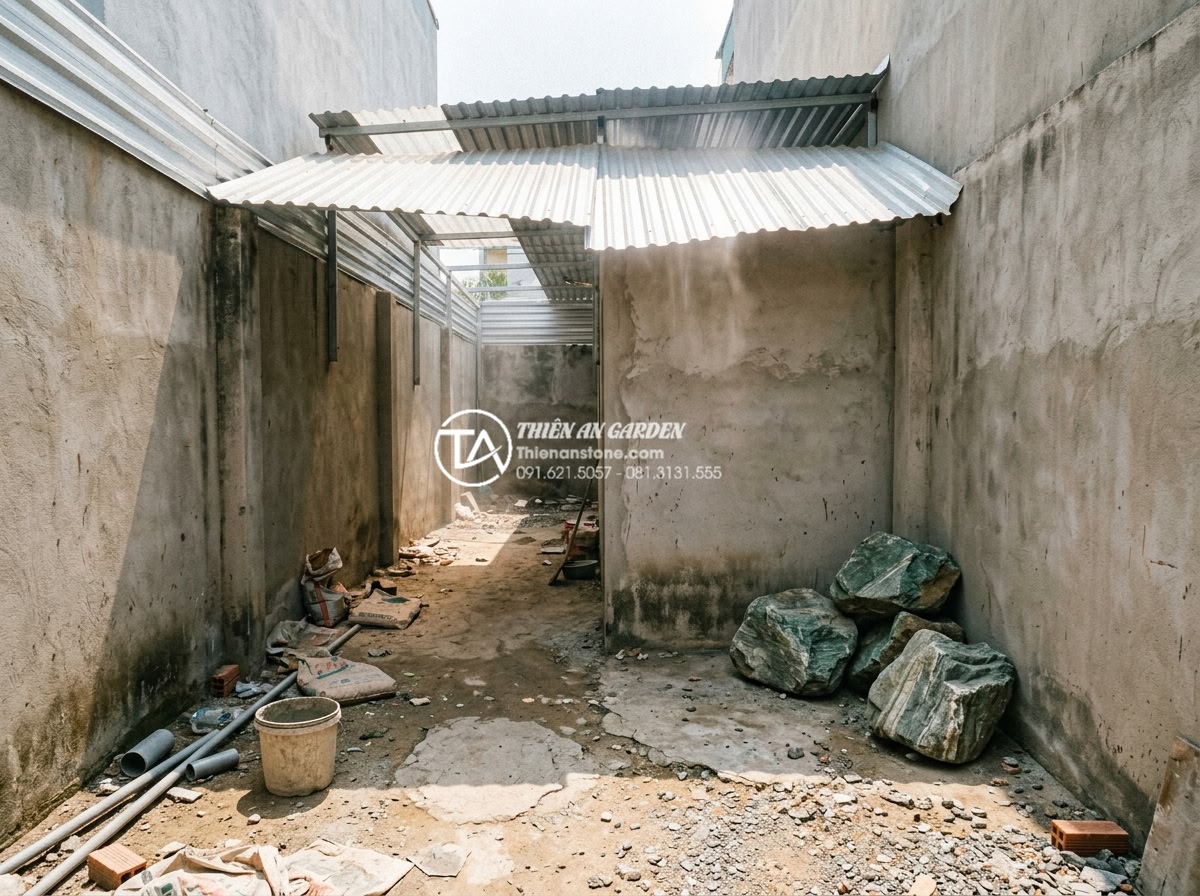 Tại sao tiểu cảnh sân sau lại là giải pháp chống nóng hiệu quả cho nhà ống? - Hình 1 Tại sao tiểu cảnh sân sau lại là giải pháp chống nóng hiệu quả cho nhà ống? - A realistic wide-angle photo of a narrow Vietnamese tube house backyard during m