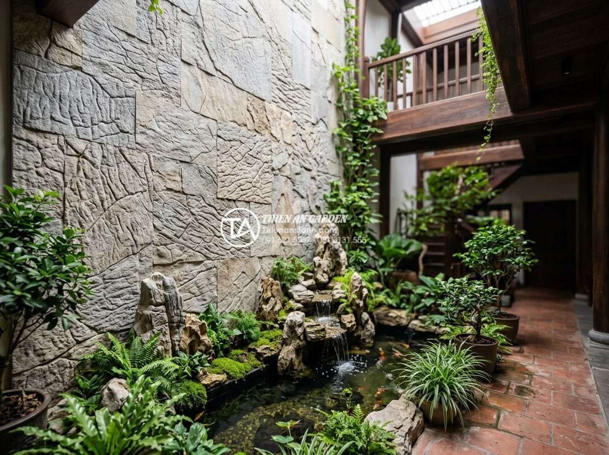 Top 5 loại đá tự nhiên ốp tường giếng trời bền đẹp và sang trọng nhất - Elegant natural stone wall cladding in sky well atrium with lush green plants an