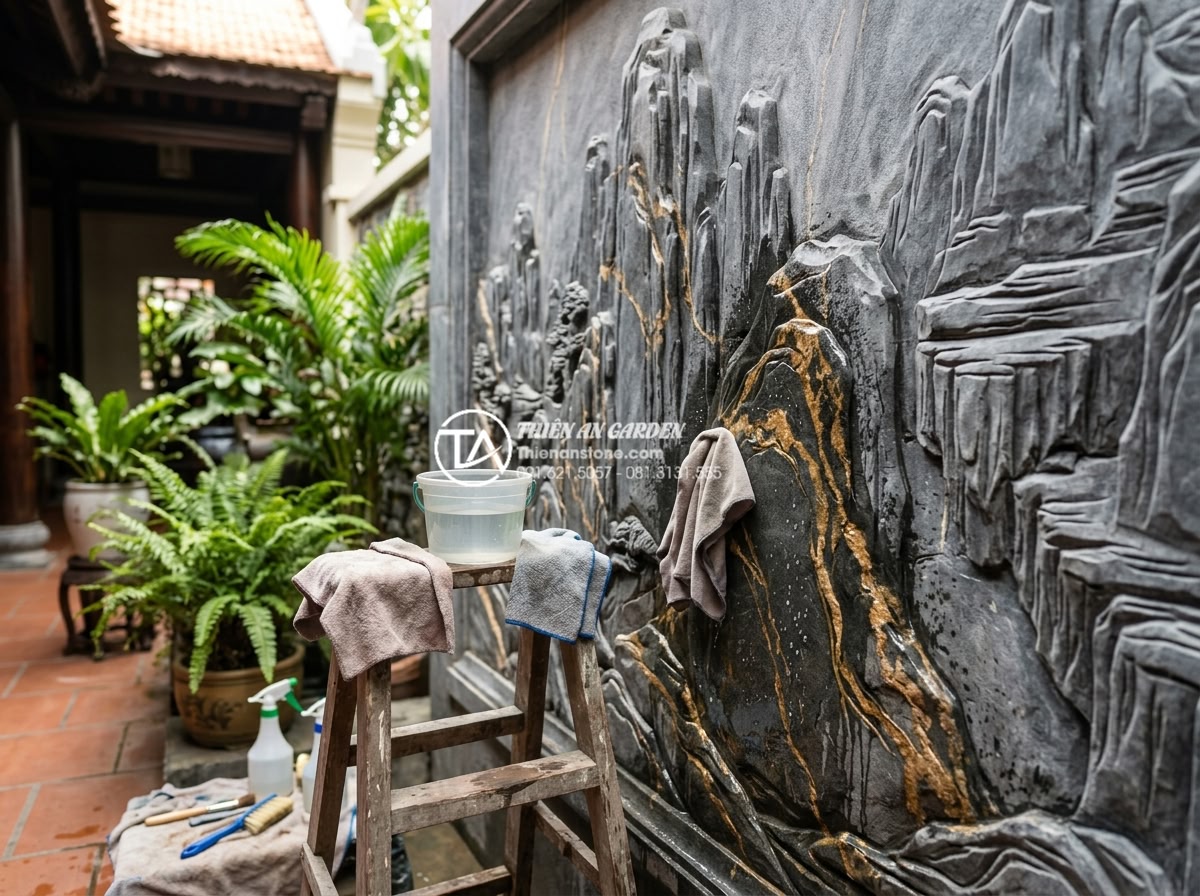 Ứng dụng tranh đá ốp tường giếng trời tạo điểm nhấn nghệ thuật - Hình 15 Ứng dụng tranh đá ốp tường giếng trời tạo điểm nhấn nghệ thuật - Maintenance process showing gentle cleaning of carved stone mural in atrium envi