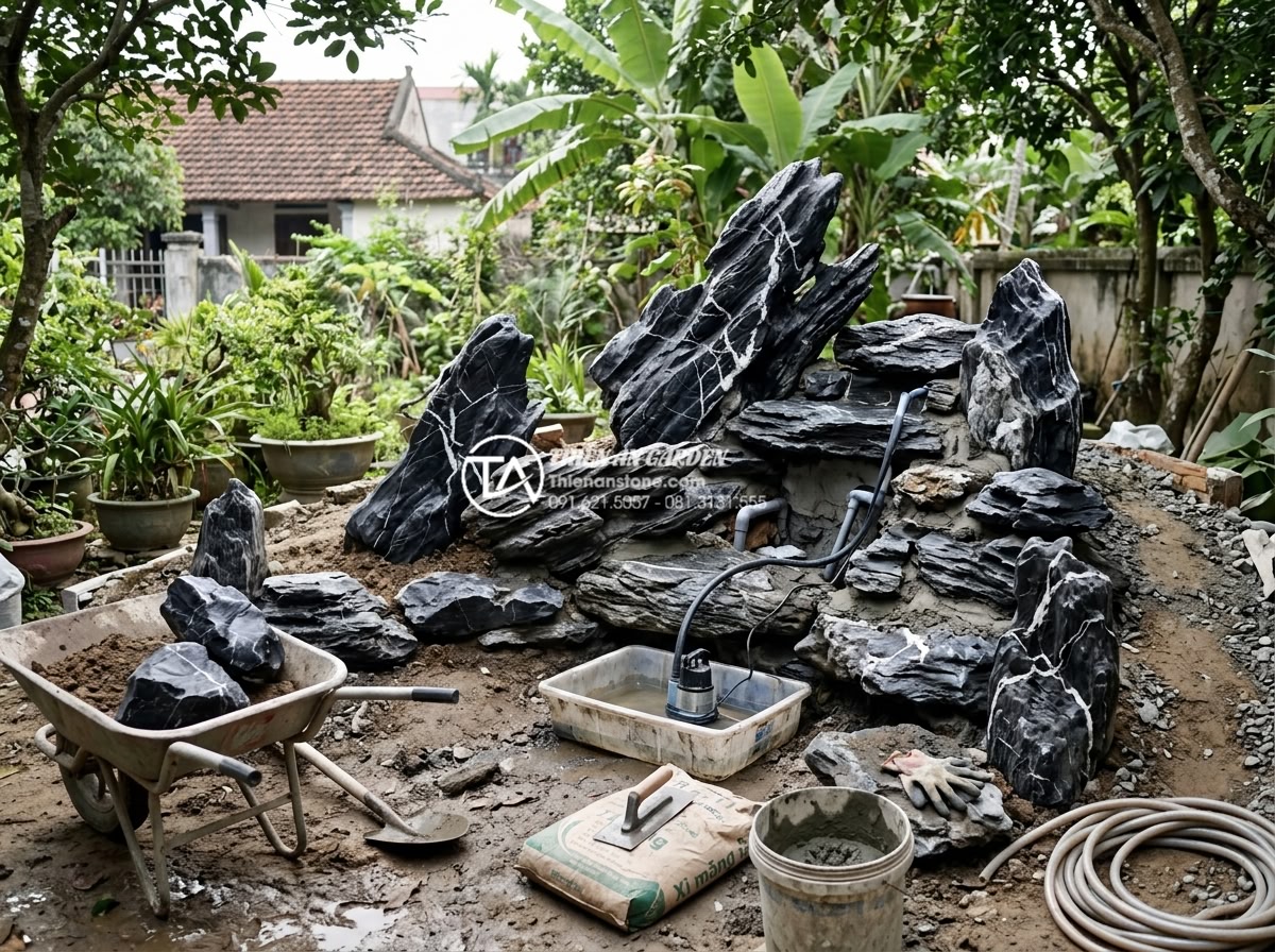 Góc nhìn chuyên gia: Nên thuê đơn vị thi công hay tự làm hòn non bộ? - Hình 3 Góc nhìn chuyên gia: Nên thuê đơn vị thi công hay tự làm hòn non bộ? - Inspiring DIY rockery project in progress showing homeowner arranging natural st