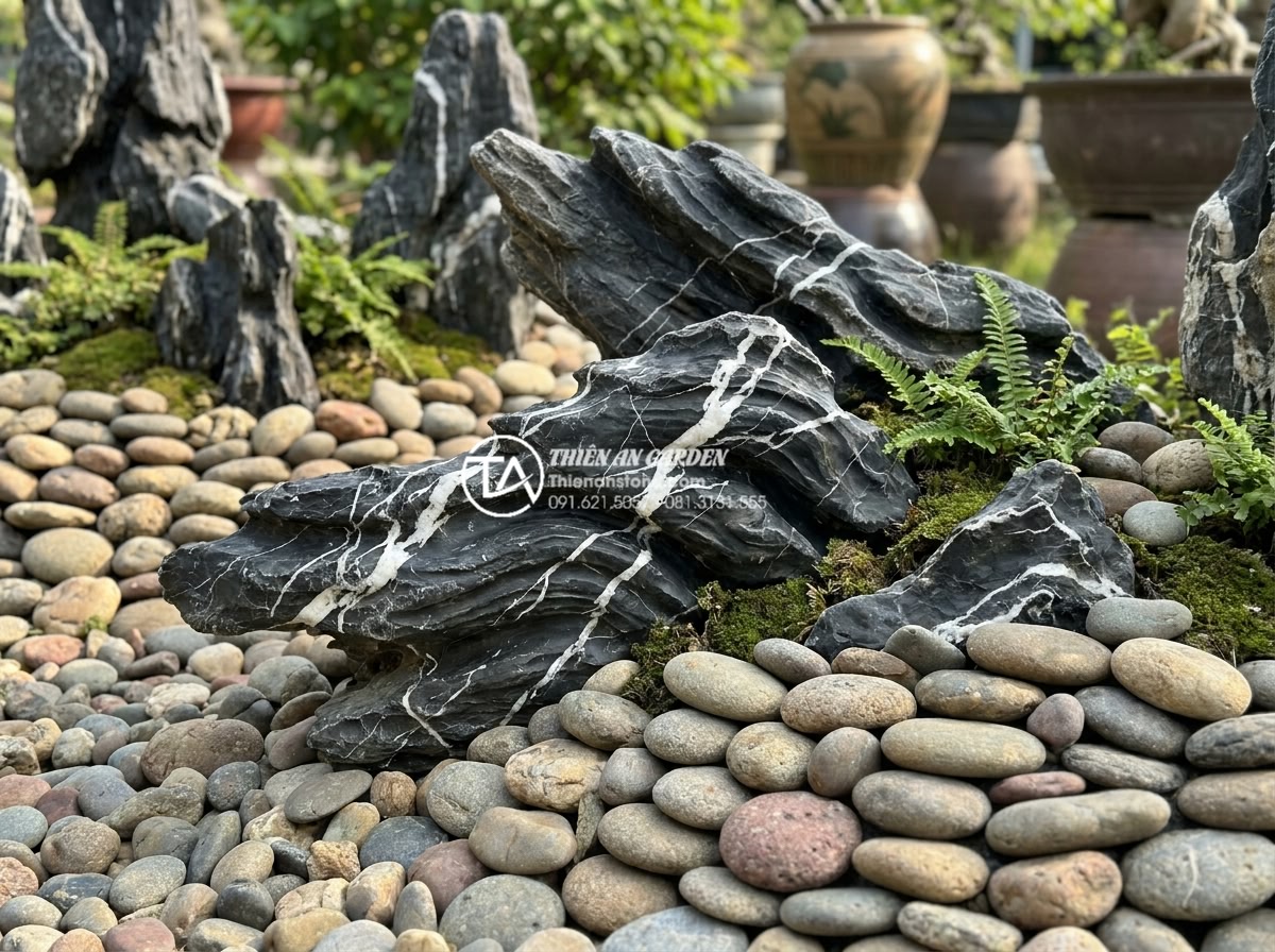 7 bí quyết sắp xếp đá cuội tự nhiên để có tiểu cảnh đẹp như tranh - Hình 11 7 bí quyết sắp xếp đá cuội tự nhiên để có tiểu cảnh đẹp như tranh - Varied size and color natural pebbles layered to create depth in landscape rock
