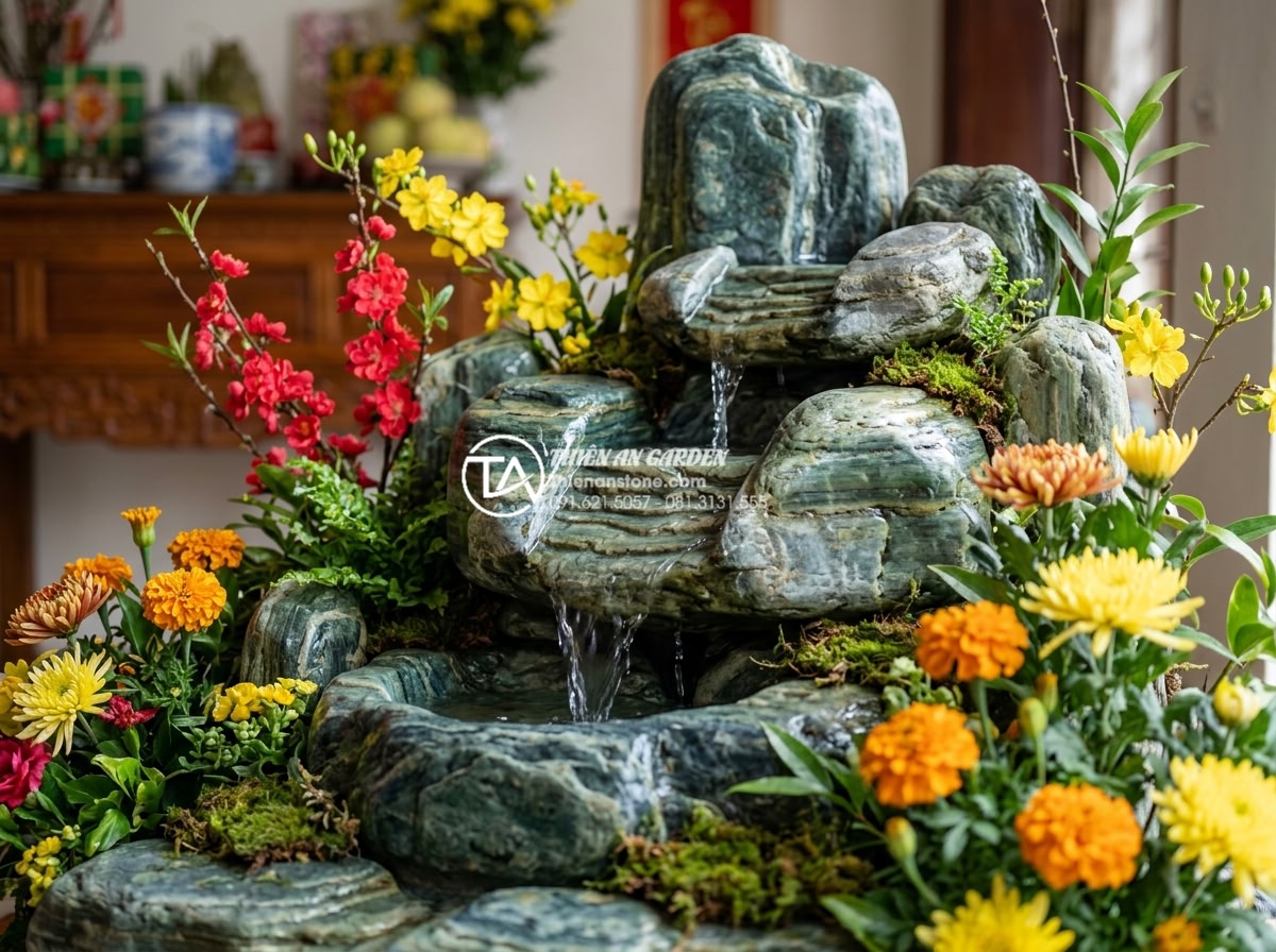 Tiểu cảnh hoa tết kết hợp thác nước: Mang hơi thở thiên nhiên vào không gian - Close-up of colorful Tet flowers arranged around a small artificial waterfall ma