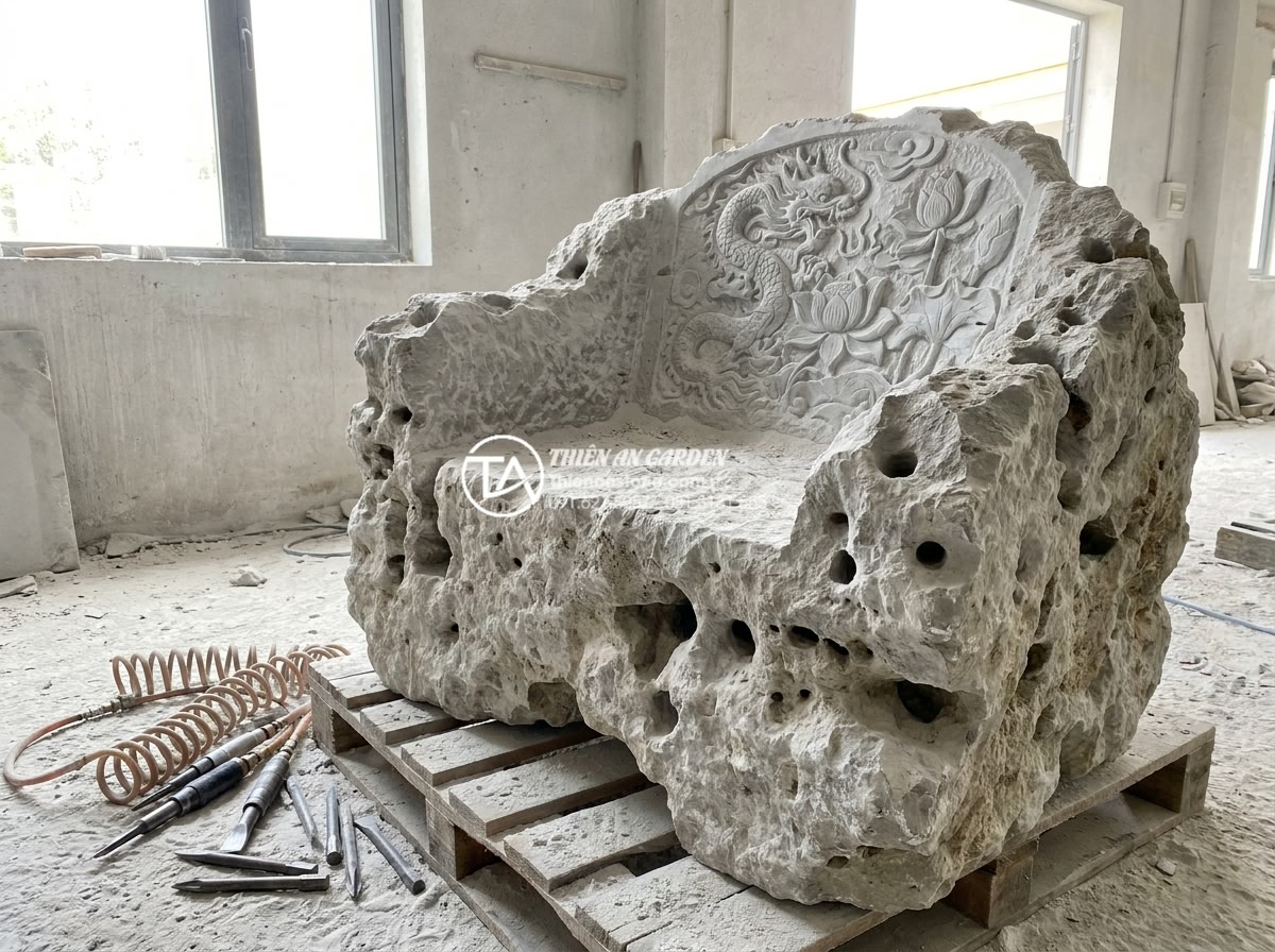 Quy trình chế tác bàn ghế đá nguyên khối từ khối đá thô đến tác phẩm hoàn thiện - Hình 11 Quy trình chế tác bàn ghế đá nguyên khối từ khối đá thô đến tác phẩm hoàn thiện - Master stone carver meticulously hand-chiseling intricate lotus flower and drago