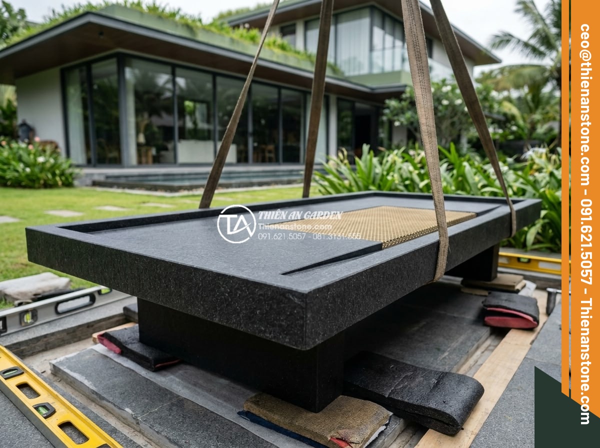 Bàn trà đá bazan (đá đen): Sự lựa chọn tối giản cho không gian hiện đại - Hình 16 Bàn trà đá bazan (đá đen): Sự lựa chọn tối giản cho không gian hiện đại - Finished beautiful black basalt stone tea table being carefully installed in a l