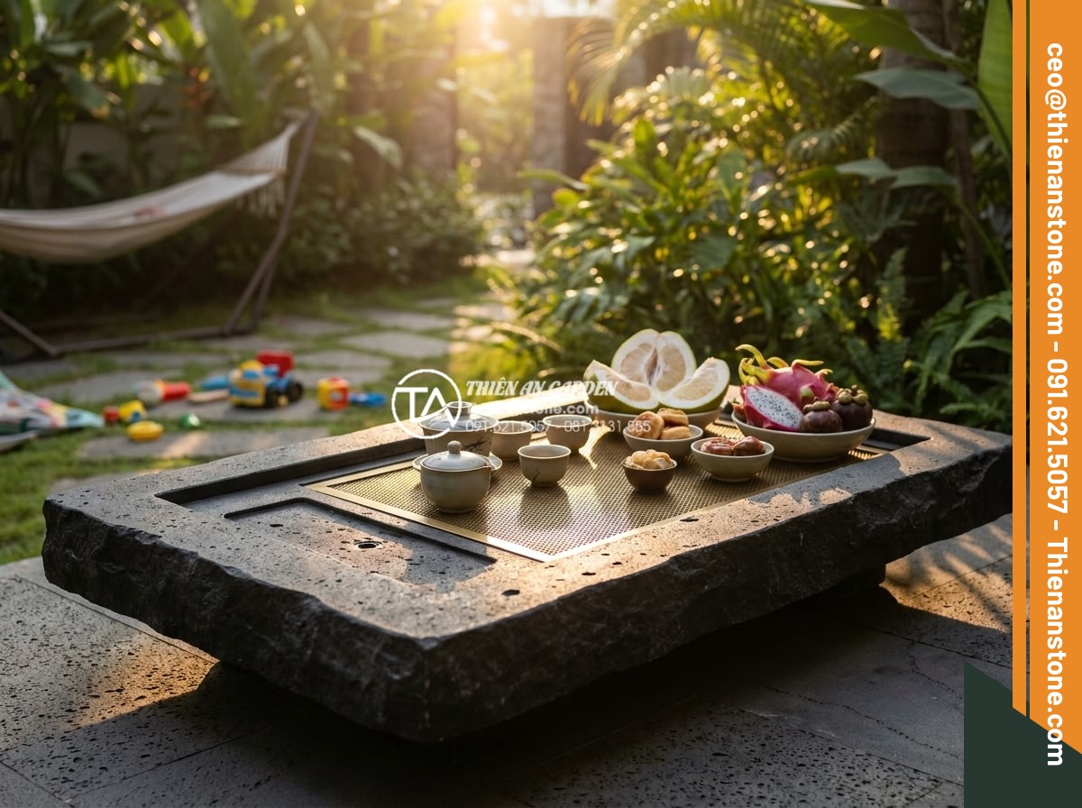 Bàn trà đá bazan (đá đen): Sự lựa chọn tối giản cho không gian hiện đại - Hình 4 Bàn trà đá bazan (đá đen): Sự lựa chọn tối giản cho không gian hiện đại - Lifestyle image of a family enjoying afternoon tea on a black basalt stone table