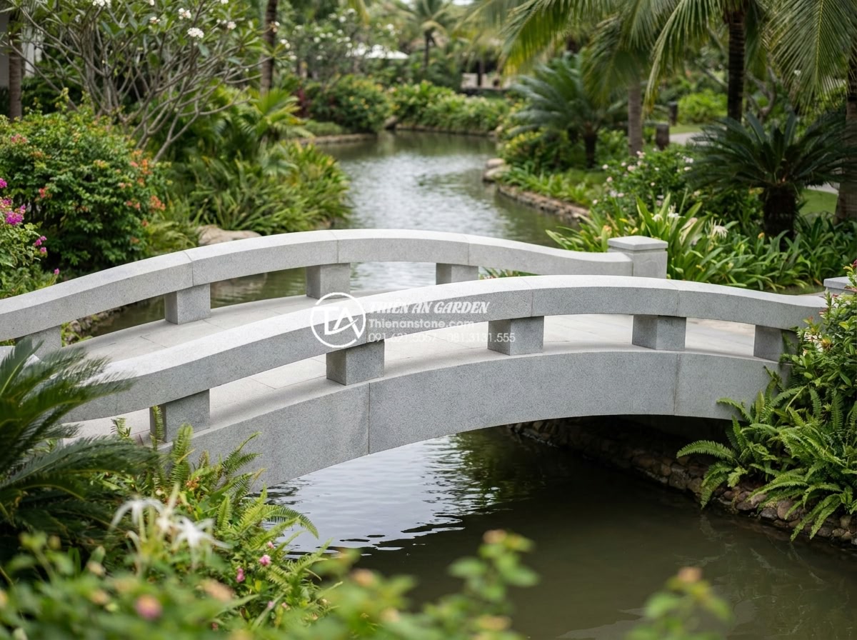 Cách chọn đá tự nhiên làm cầu sân vườn bền bỉ và không bị rêu mốc - Wide angle professional shot of a sturdy granite stone bridge spanning a serene 
