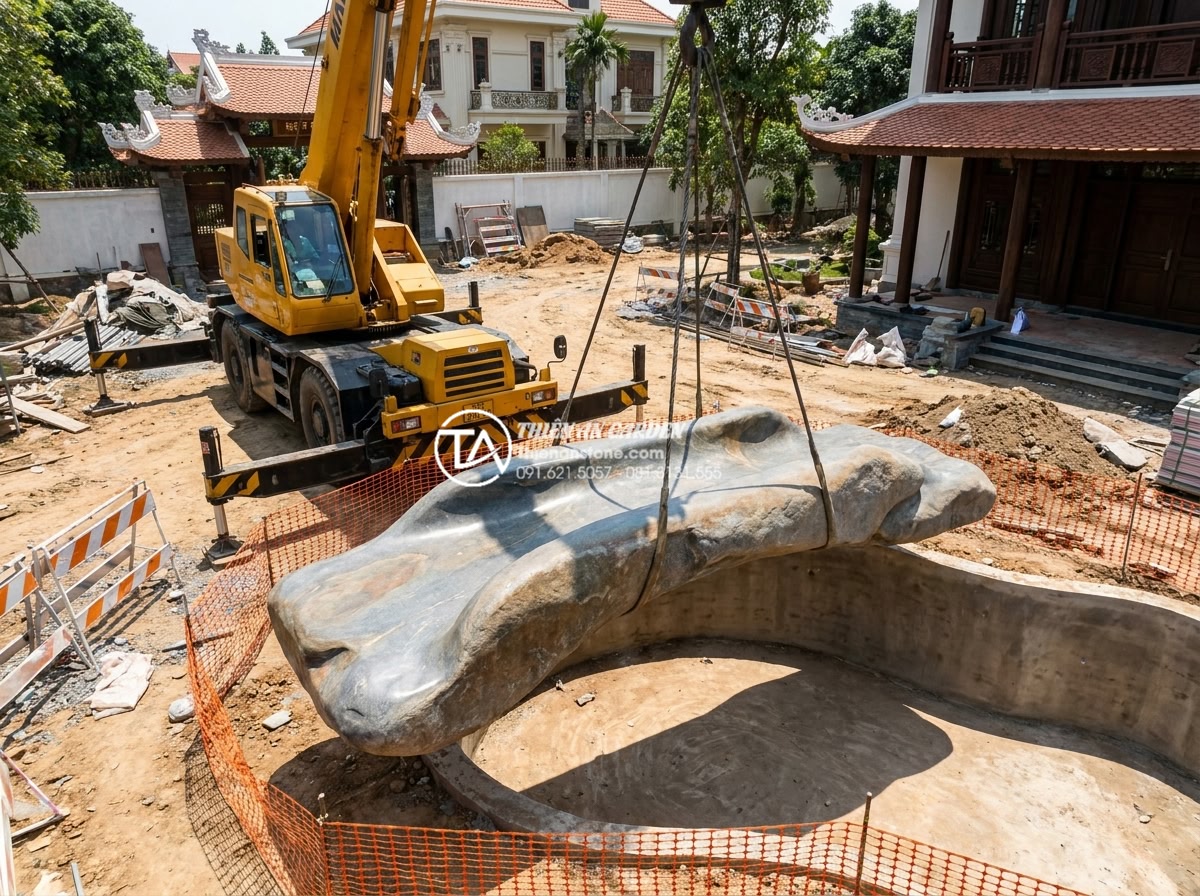 Case study: Cải tạo sân vườn biệt thự 500m2 với điểm nhấn cầu đá nguyên khối - Hình 6 Case study: Cải tạo sân vườn biệt thự 500m2 với điểm nhấn cầu đá nguyên khối - Construction site photograph of heavy crane lifting the finished monolithic ston