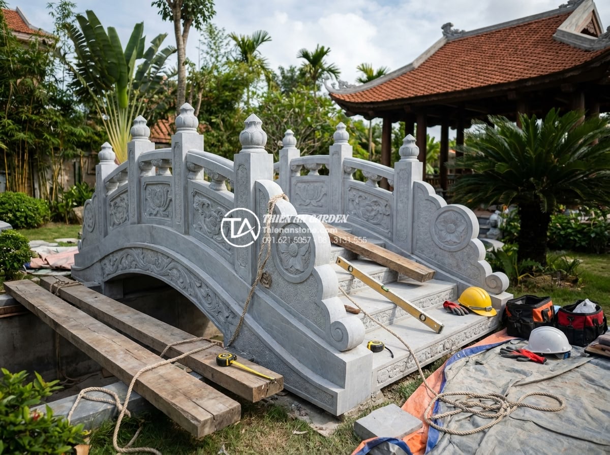 Cầu trang trí sân vườn bằng đá tự nhiên: Ưu điểm vượt trội so với gỗ và bê tông - Hình 10 Cầu trang trí sân vườn bằng đá tự nhiên: Ưu điểm vượt trội so với gỗ và bê tông - Professional team of Vietnamese stone artisans carefully installing a large carv
