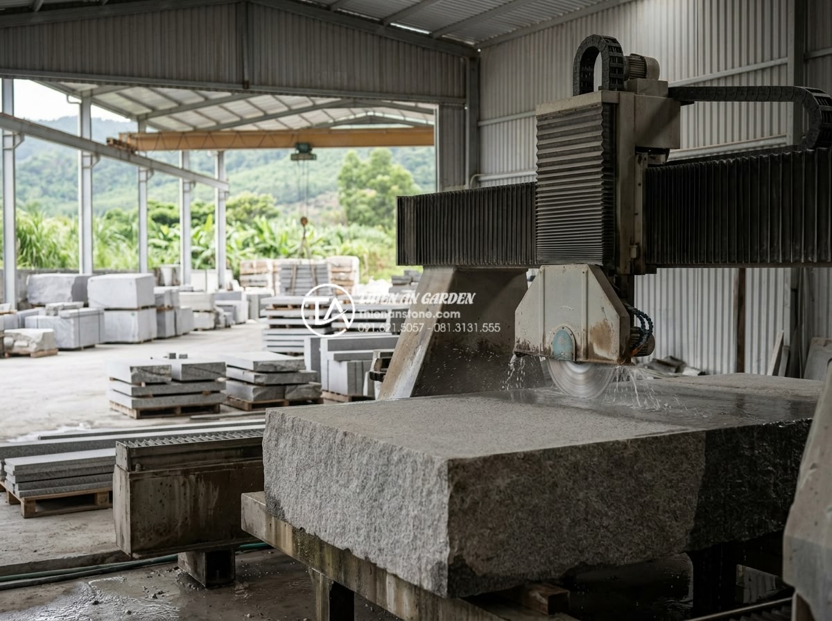 Giải đáp: Thời gian thi công một mẫu cầu đá chạm khắc mất bao lâu? - Hình 5 Giải đáp: Thời gian thi công một mẫu cầu đá chạm khắc mất bao lâu? - Industrial workshop scene with large granite blocks being precisely cut by CNC m