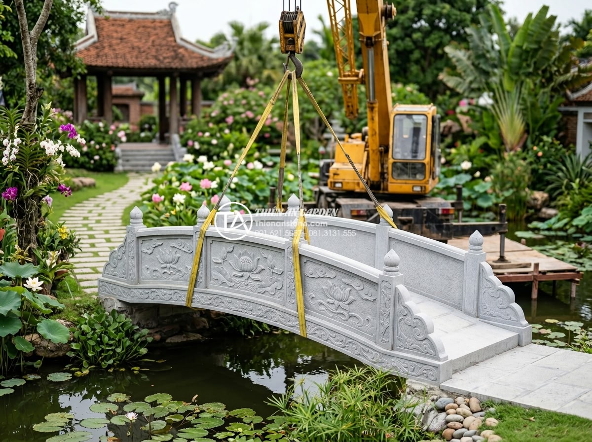 Giải đáp: Thời gian thi công một mẫu cầu đá chạm khắc mất bao lâu? - Hình 7 Giải đáp: Thời gian thi công một mẫu cầu đá chạm khắc mất bao lâu? - Construction team carefully installing a finished carved stone garden bridge ove