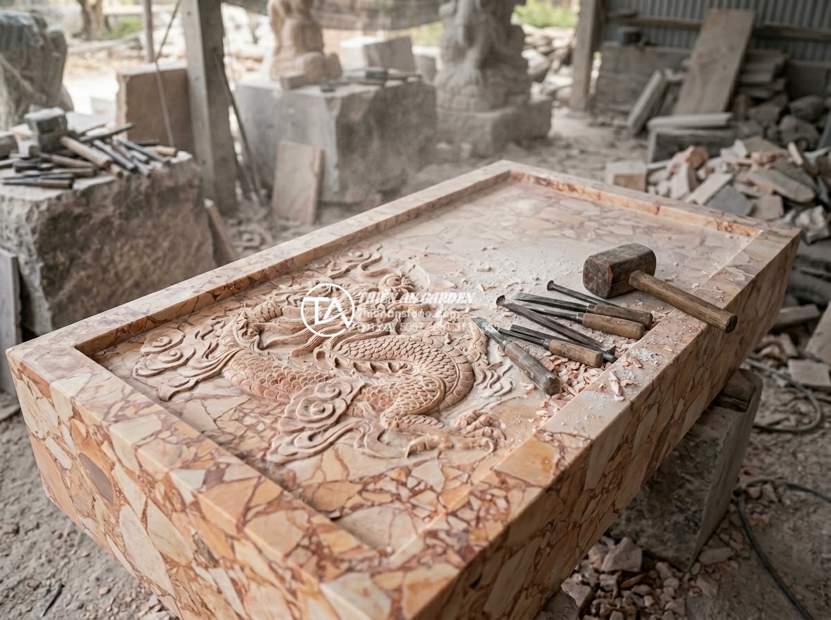 Sự khác biệt giữa bàn trà đá nguyên khối Việt Nam và đá nhập khẩu - Behind-the-scenes workshop photo of Vietnamese artisans hand-carving intricate d