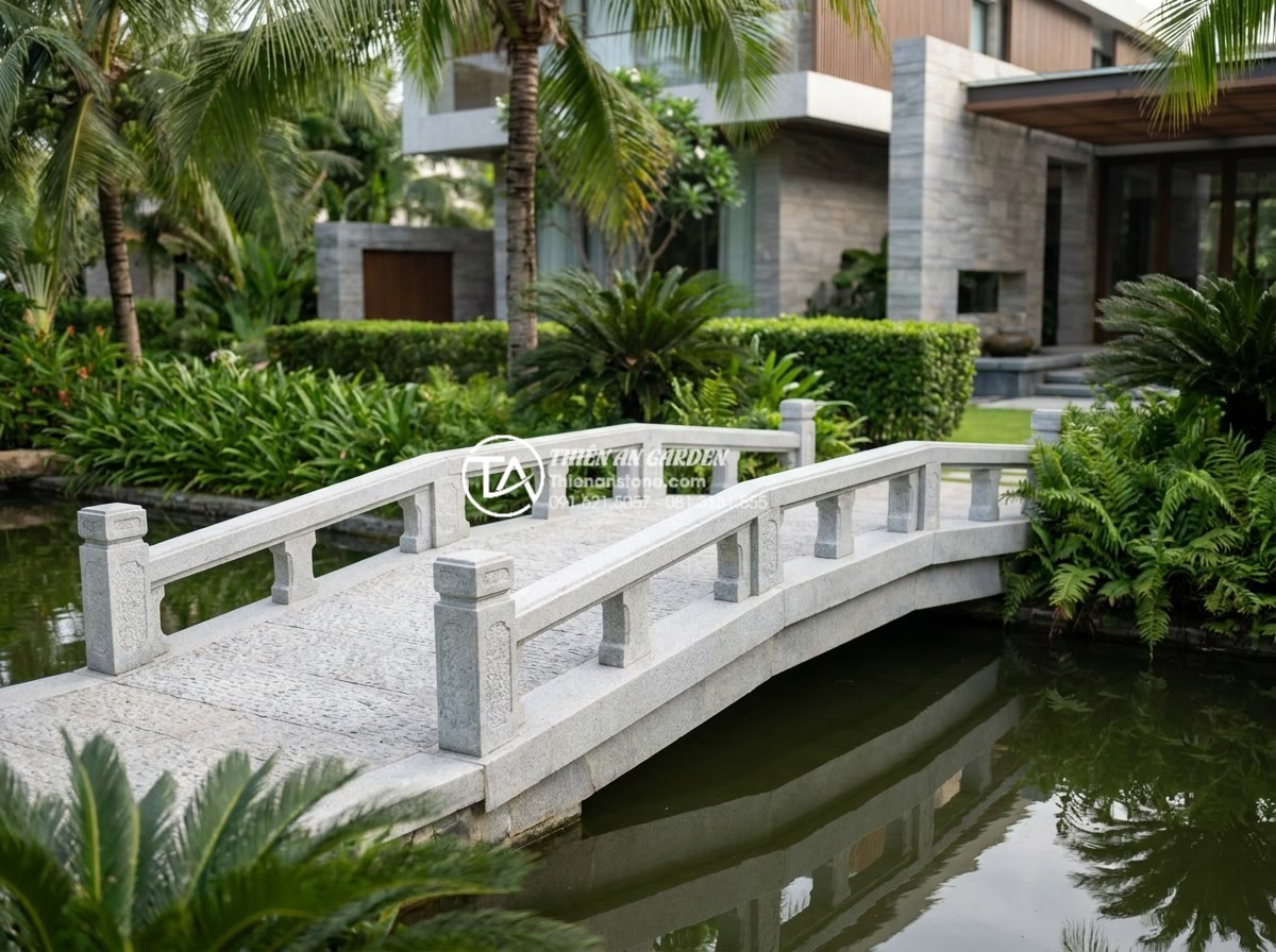 Sự khác biệt giữa đá Granite và đá Cẩm Thạch khi chế tác cầu sân vườn - Beautiful finished granite garden bridge installed over a tranquil pond in a mod