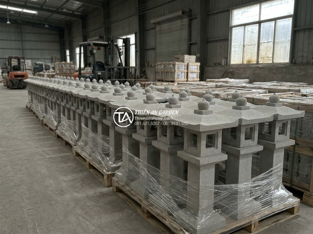 Sự khác biệt giữa đèn đá chế tác máy và đèn đá đục tay thủ công - Row of identical machine-made stone lanterns lined up in a factory warehouse rea
