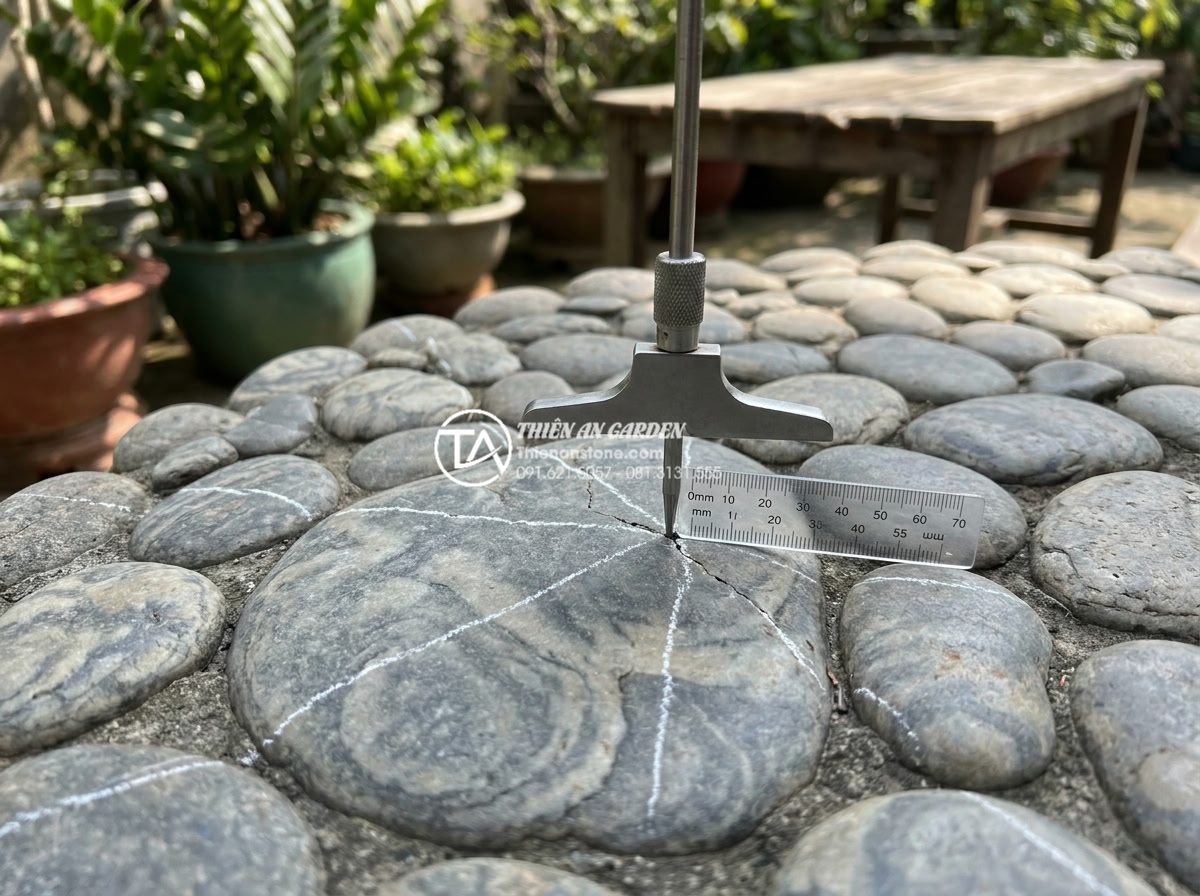Tại sao bàn ghế đá hoa cương thường bị nứt khi để ngoài trời và cách khắc phục? - Hình 11 Tại sao bàn ghế đá hoa cương thường bị nứt khi để ngoài trời và cách khắc phục? - Close-up diagnostic photograph of granite table surface with early hairline crac