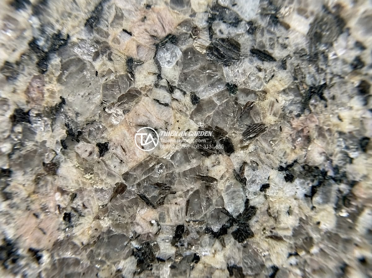 Tại sao bàn ghế đá hoa cương thường bị nứt khi để ngoài trời và cách khắc phục? - Hình 2 Tại sao bàn ghế đá hoa cương thường bị nứt khi để ngoài trời và cách khắc phục? - Detailed cross-section macro photography of premium granite stone slab showing i