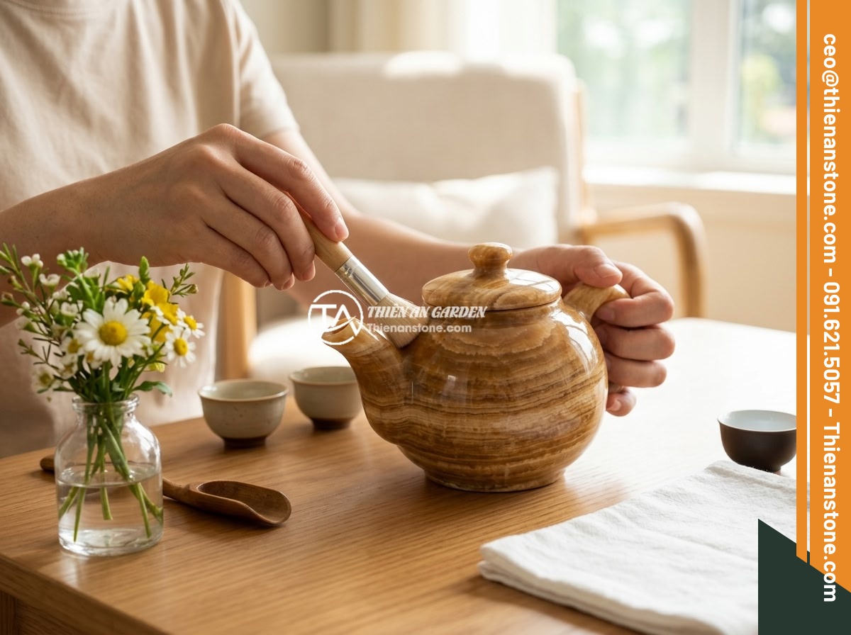 10 ý tưởng decor bàn trà đẹp mắt với bộ ấm chén đá phong thủy - A person carefully cleaning a natural stone teapot with a soft brush, next to a 