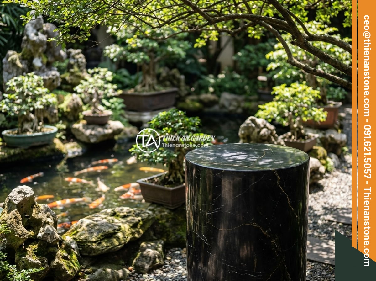 Cách bảo quản và vệ sinh đôn đá tự nhiên luôn sáng bóng, bền màu - A natural stone pedestal placed in a beautifully landscaped outdoor Vietnamese g