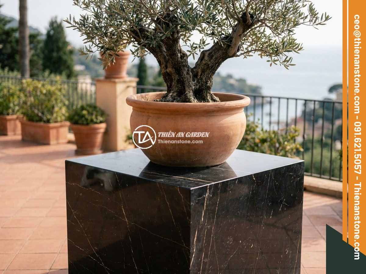 Checklist 10 bước chọn mua đôn đá tự nhiên chất lượng, bền đẹp lâu dài - A sturdy natural stone pedestal supporting a heavy ceramic pot with a large orna