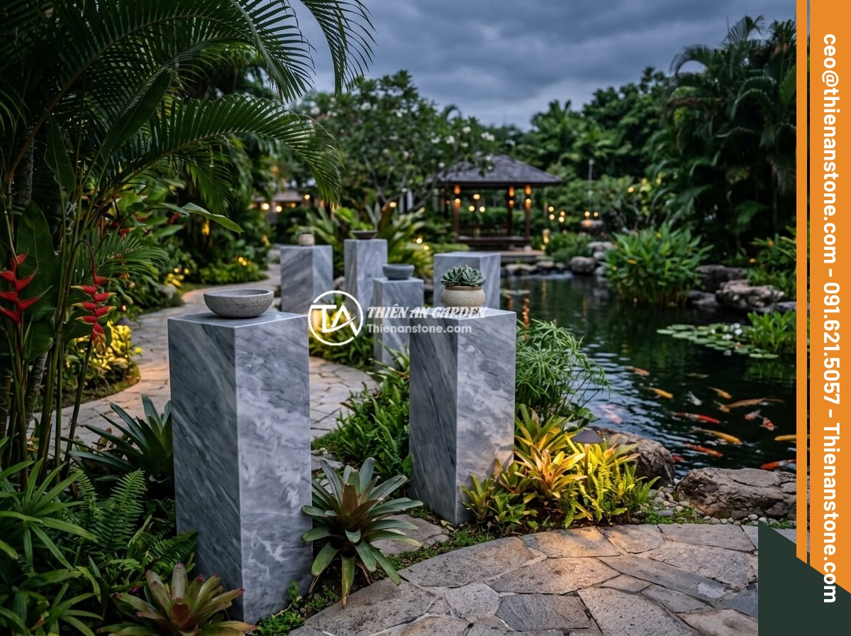 Đôn đá mài là gì? Đặc điểm, ưu điểm và ứng dụng trong không gian hiện đại - Elegant polished stone pedestals arranged in a luxury resort garden with tropica