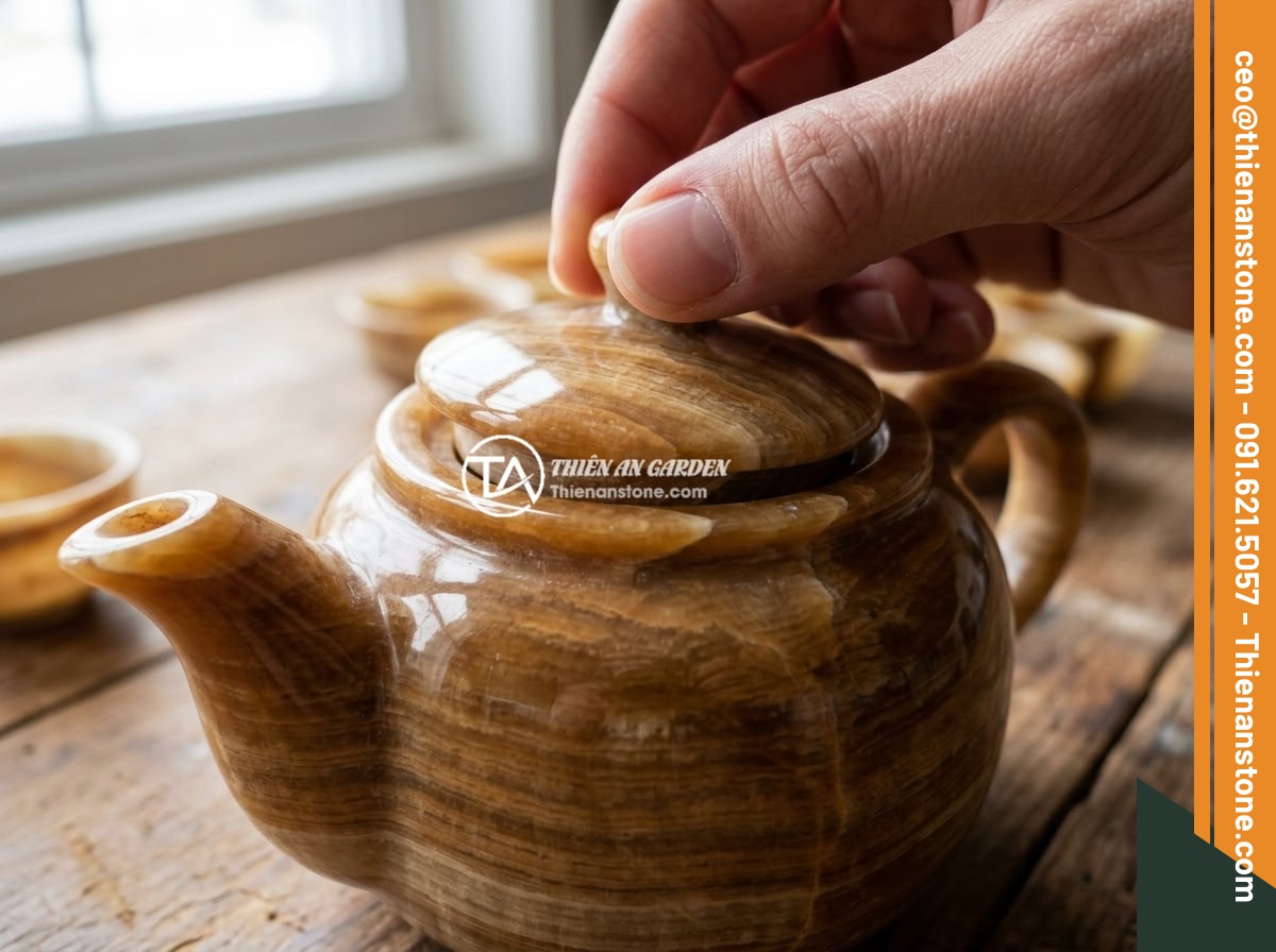 Kinh nghiệm pha trà ngon và chuẩn vị với ấm chén đá tự nhiên - Close-up of a high-quality natural stone tea set being inspected, showing the sm