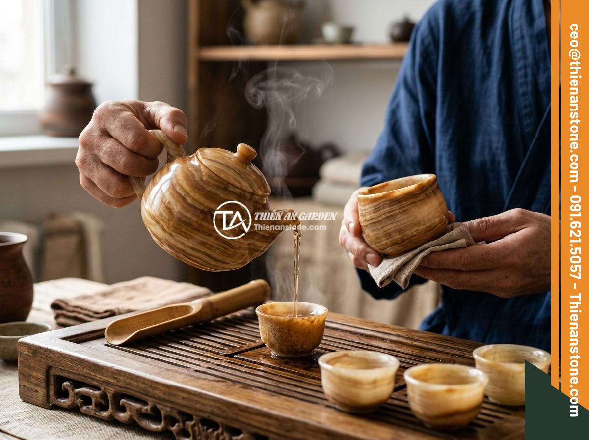 Quà tặng cao cấp 2026: Tại sao bộ ấm chén đá quý lại được lựa chọn nhiều - A person pouring hot tea from a polished jade stone teapot into small stone cups