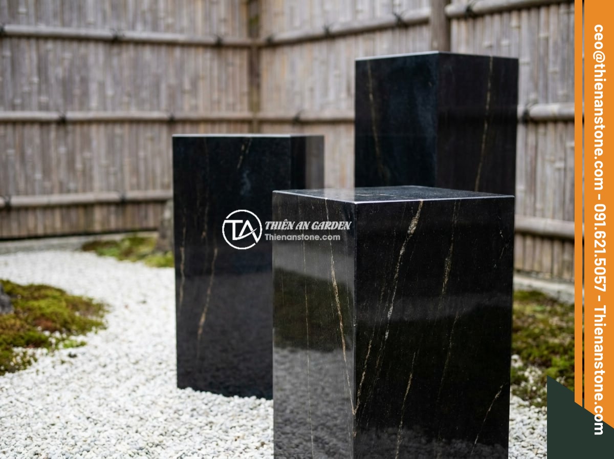 Top chất liệu đá tự nhiên làm đôn đá: Granite, bazan, cuội vân mây và đặc tính - Hình 3 Top chất liệu đá tự nhiên làm đôn đá: Granite, bazan, cuội vân mây và đặc tính - Black basalt stone pedestals placed in a minimalist Japanese Zen garden with whi