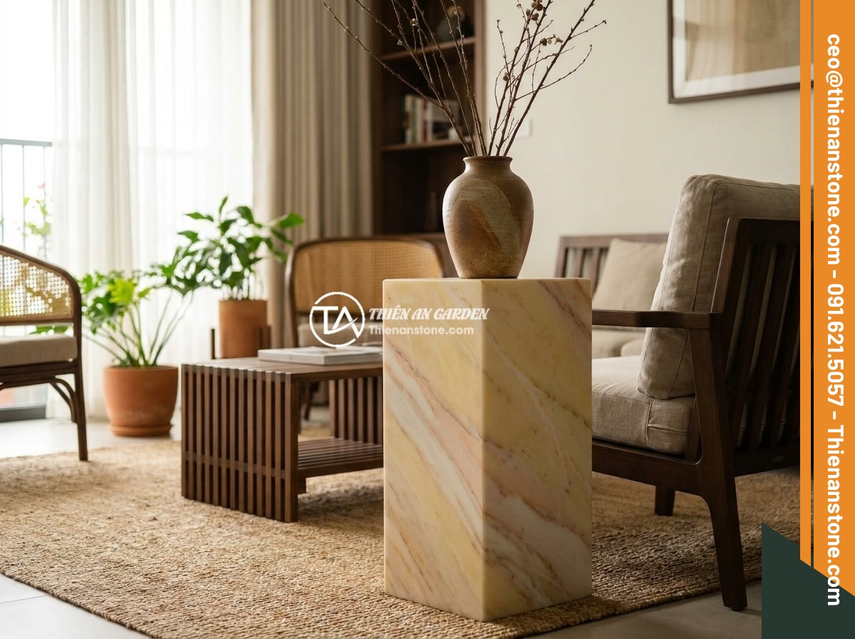 Top chất liệu đá tự nhiên làm đôn đá: Granite, bazan, cuội vân mây và đặc tính - Hình 7 Top chất liệu đá tự nhiên làm đôn đá: Granite, bazan, cuội vân mây và đặc tính - Interior design showcase with a cloud-veined pebble stone pedestal holding a cer