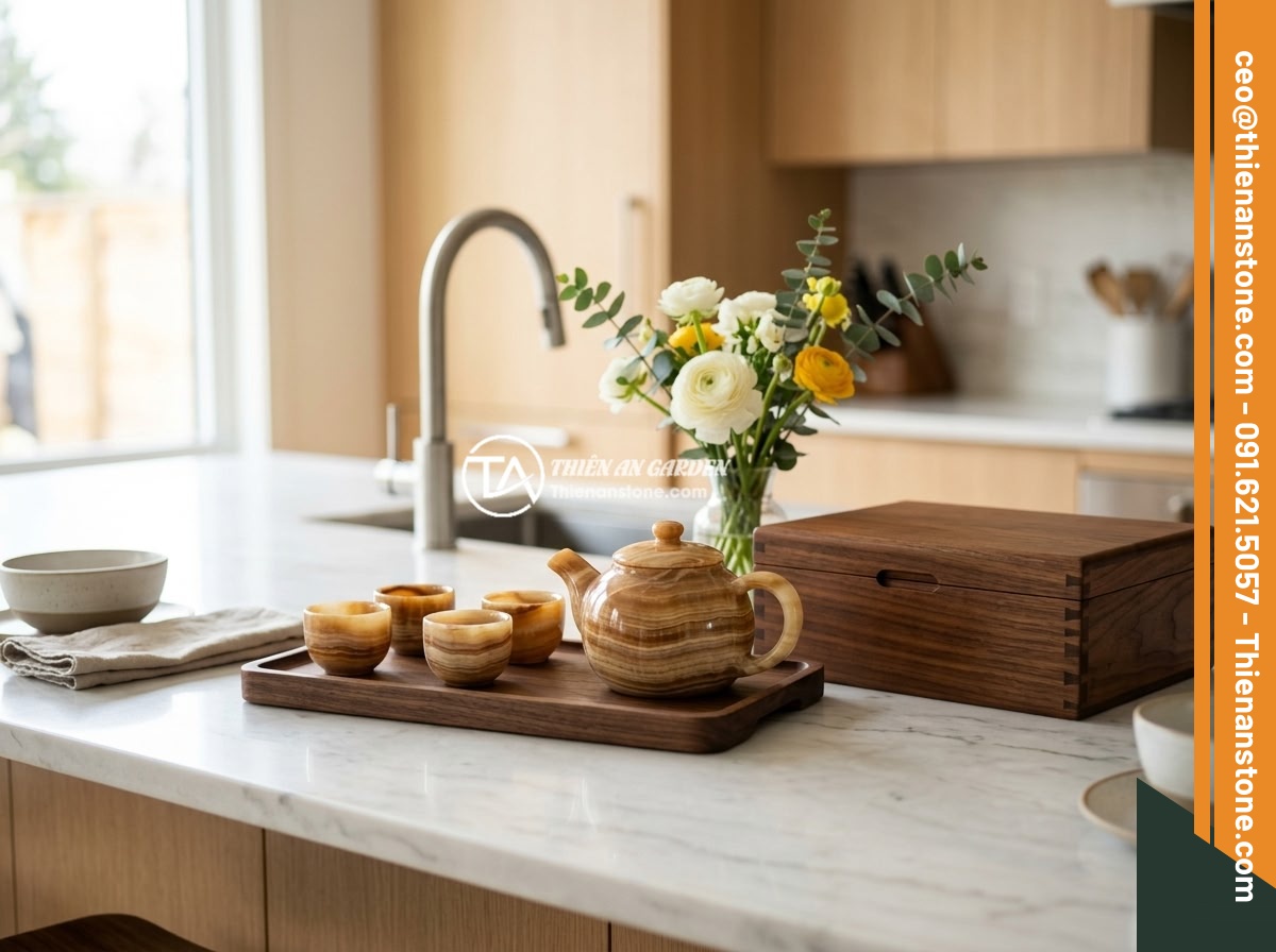Ứng dụng thực tế bộ ấm chén bằng đá trong trang trí nội thất hiện đại - A stone tea set arrangement on a modern kitchen island counter with natural marb