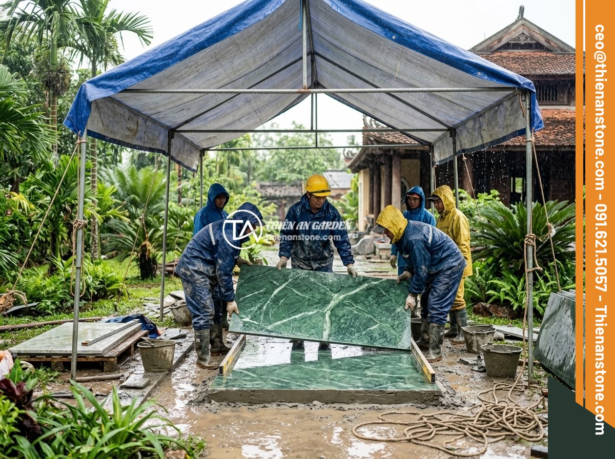 Case Study Thực Tế Thi Công Sập Đá Nguyên Khối Cho Biệt Thự Miền Bắc Việt Nam - Construction team working in rainy weather conditions at a Vietnamese villa gard