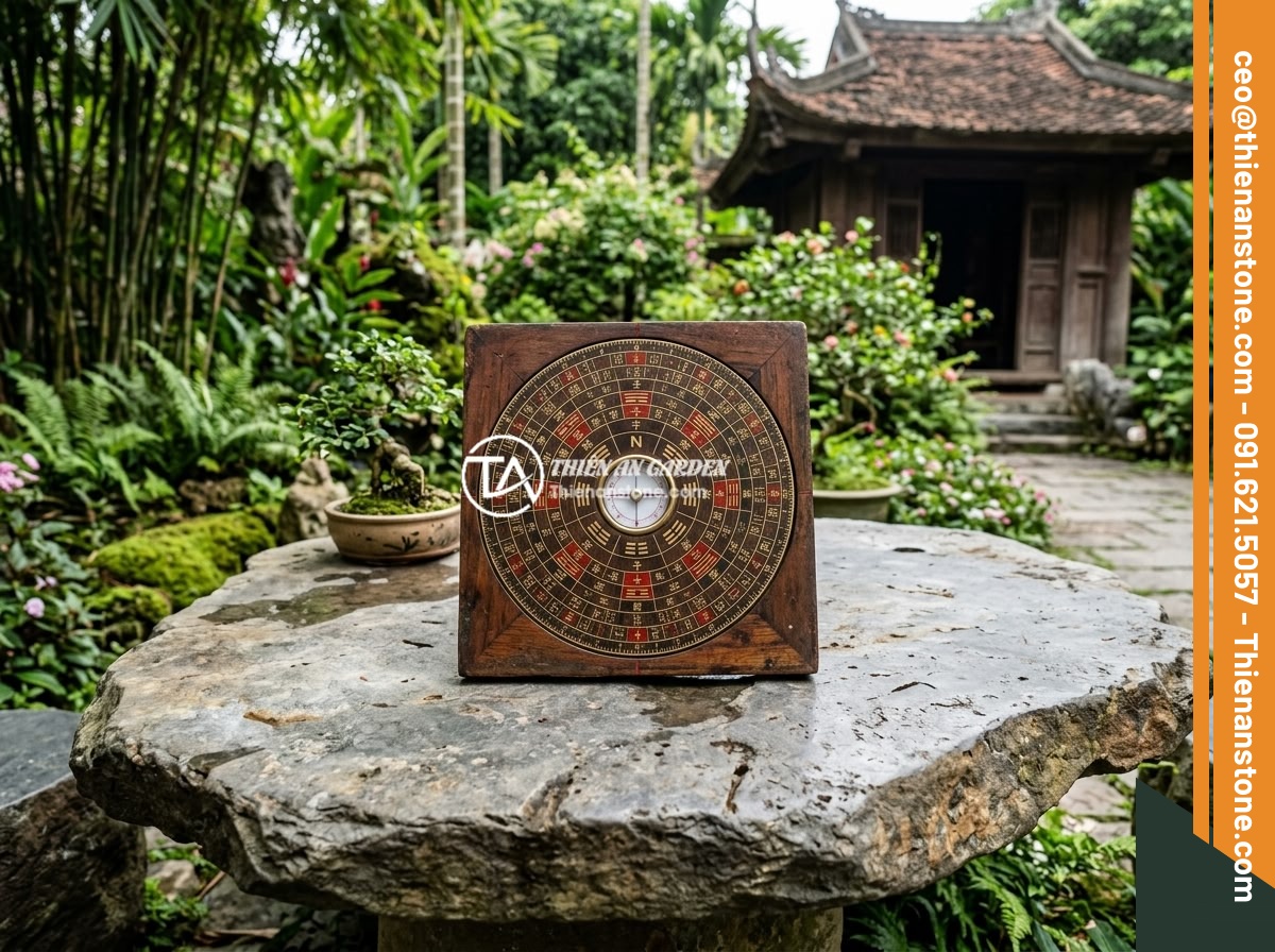 Chọn Kích Thước Sập Đá Phù Hợp Sân Vườn Biệt Thự: Hướng Dẫn Tối Ưu Diện Tích - Hình 6 Chọn Kích Thước Sập Đá Phù Hợp Sân Vườn Biệt Thự: Hướng Dẫn Tối Ưu Diện Tích - A feng shui compass (lo ban ruler) placed on a natural stone slab table in a Vie