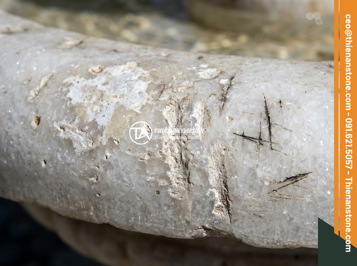 Đài Phun Nước Đá Bị Rêu Xanh Bám: Nguyên Nhân & 5 Cách Xử Lý Hiệu Quả - Hình 9 Đài Phun Nước Đá Bị Rêu Xanh Bám: Nguyên Nhân & 5 Cách Xử Lý Hiệu Quả - Damaged stone fountain surface showing chemical burns, acid etching marks, and m