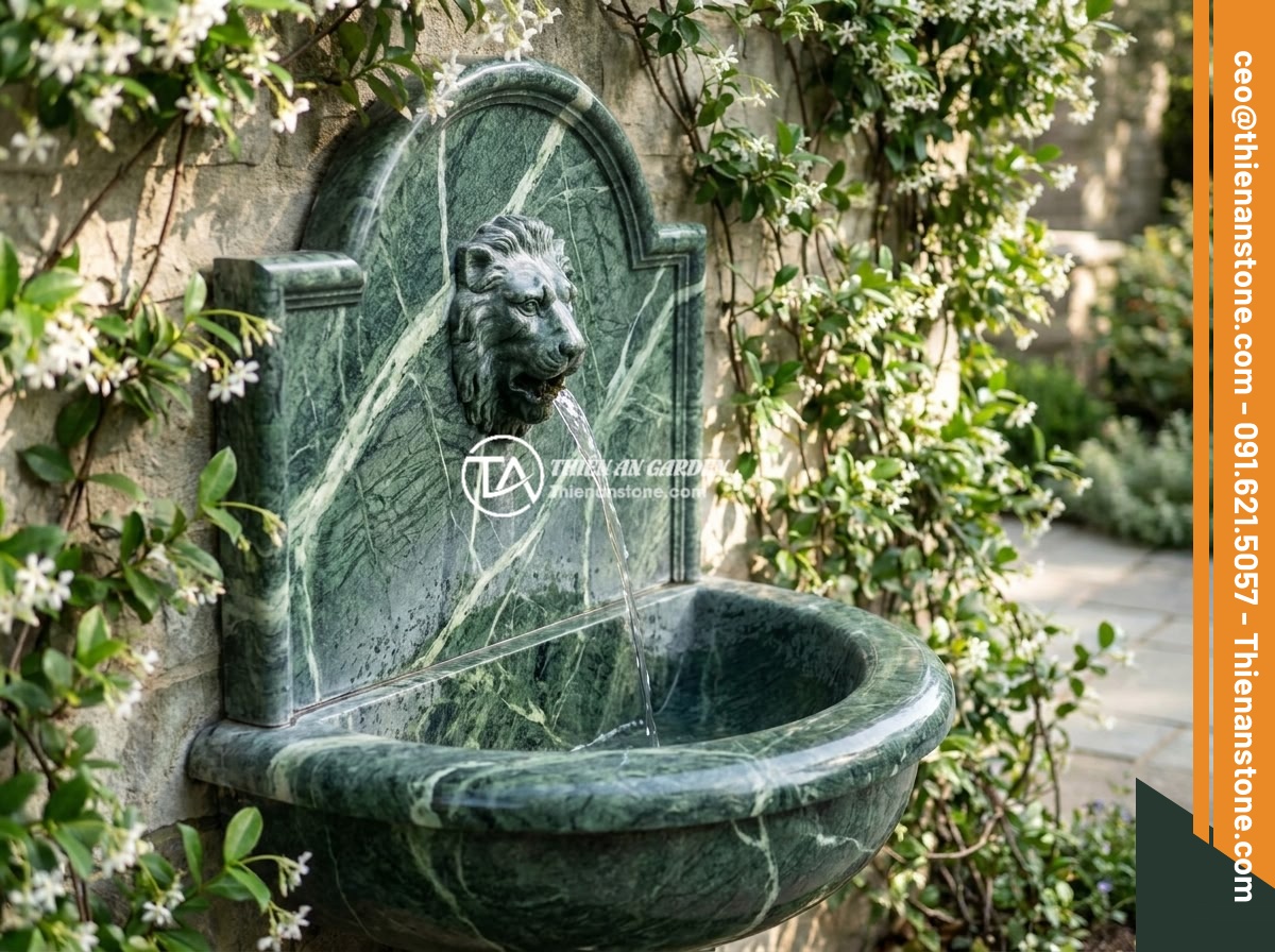 Top 12 Mẫu Đài Phun Nước Bằng Đá Đẹp Sang Trọng Cho Sân Vườn Biệt Thự 2026 - A beautiful wall-mounted stone fountain with a lion head spout carved from sands