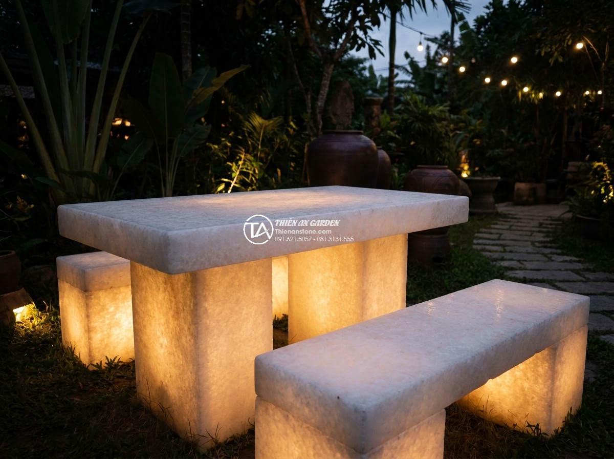 Bàn ghế đá trắng muối - Hình 12 Bàn ghế đá trắng muối - Evening view of white salt stone furniture illuminated by soft garden lights, gl