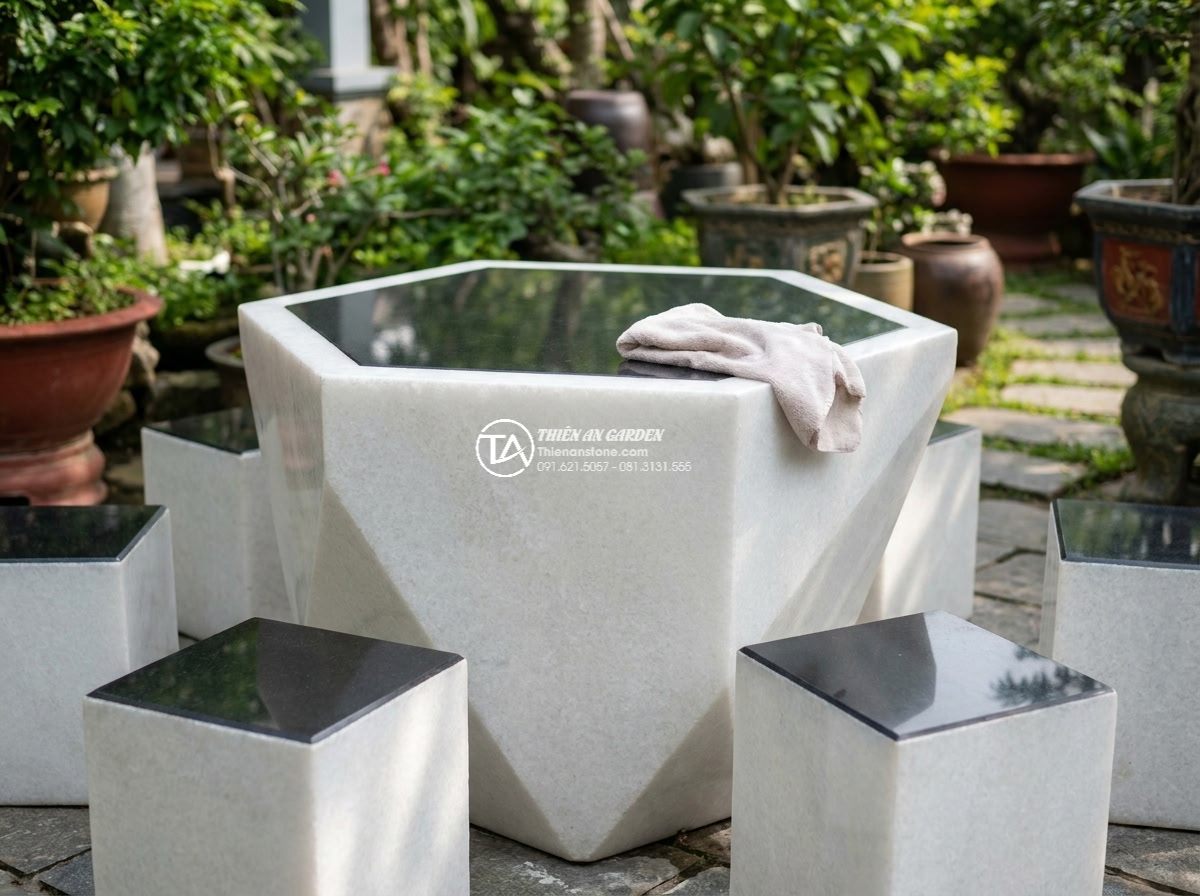 Bàn ghế đá trắng muối - Hình 21 Bàn ghế đá trắng muối - Person gently cleaning white salt stone table surface with soft cloth in garden