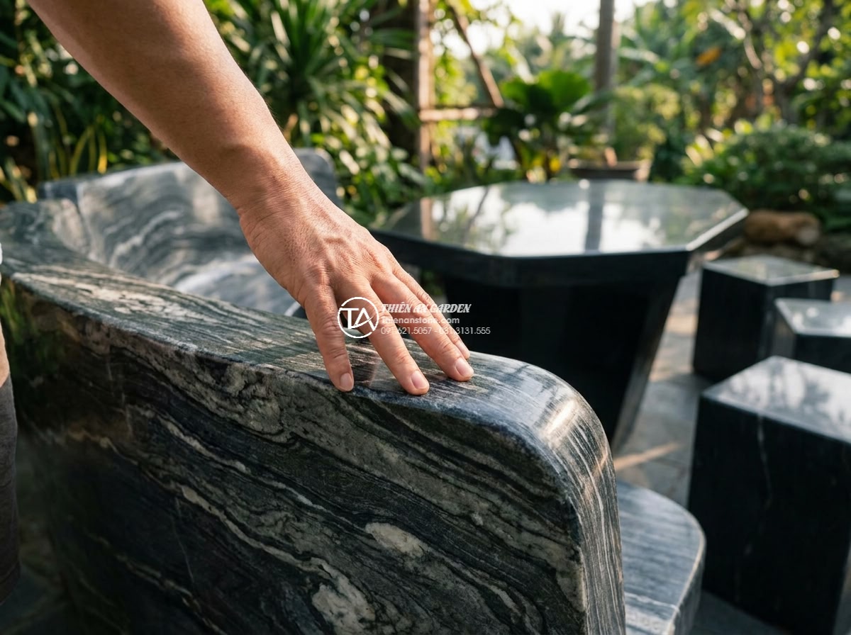 Bàn ghế đá vân mây - Hình 6 Bàn ghế đá vân mây - Intimate photorealistic close-up of a person's hand gently touching the smooth p