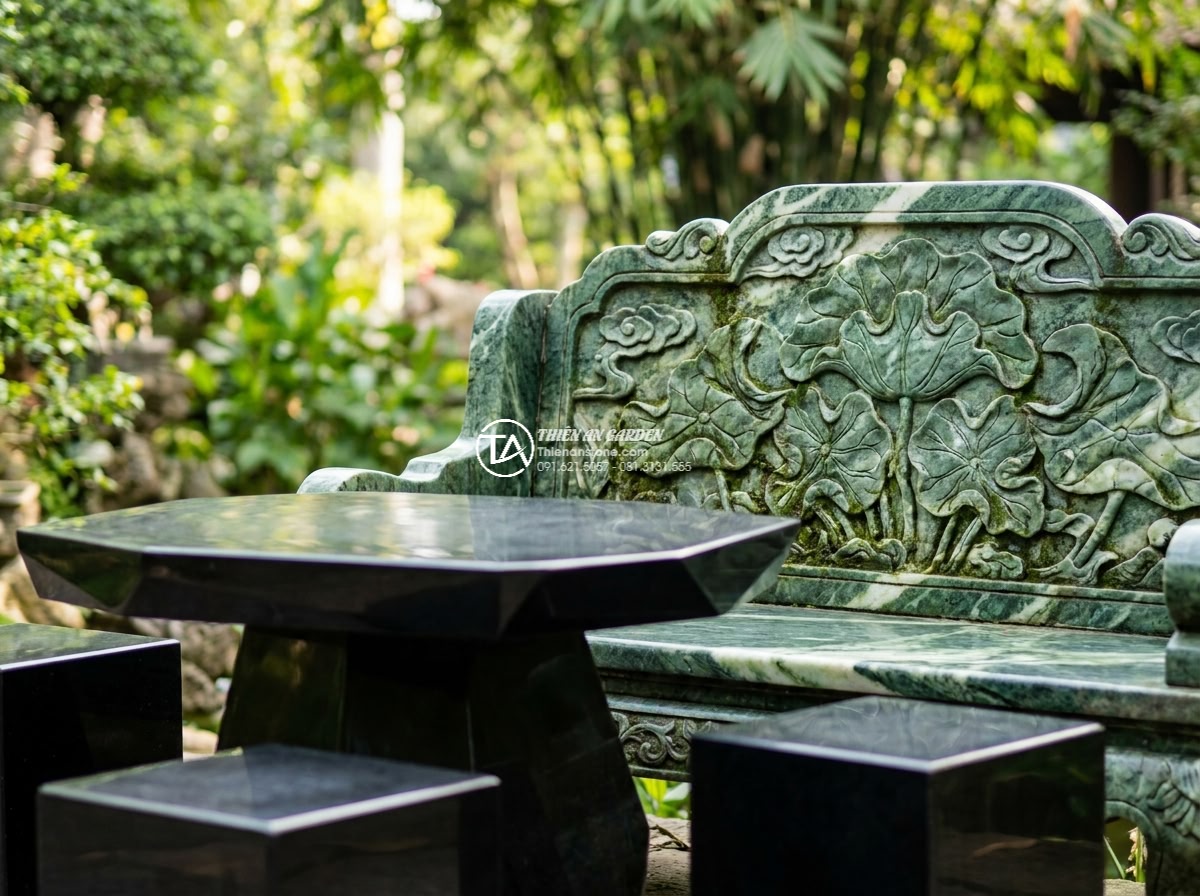 Bàn ghế đá xanh Cốm - Hình 2 Bàn ghế đá xanh Cốm - Close-up medium shot of intricate hand-carved details on a green moss stone chai