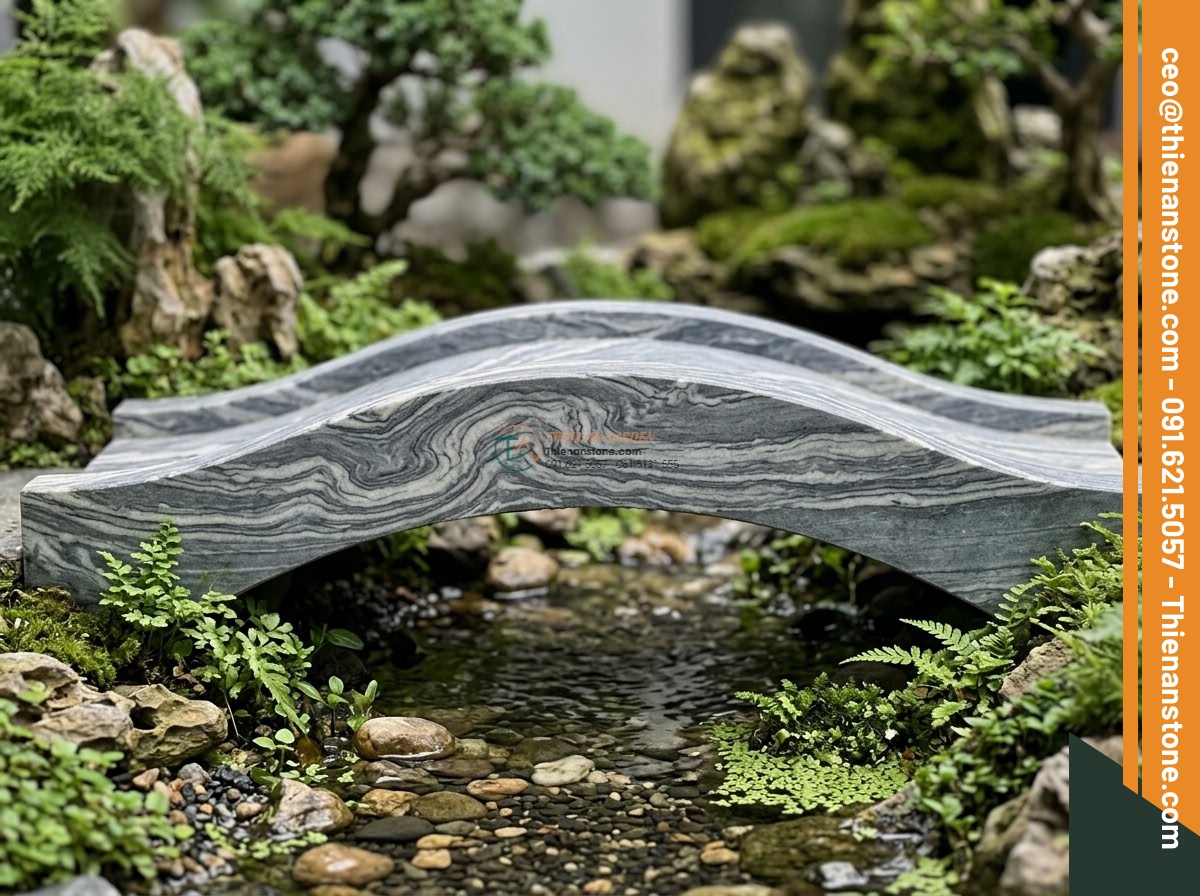 Cầu nhịp đơn đá vân mây trang trí non bộ: 100 x 40 x 10 cm. - Hình 2 Cầu nhịp đơn đá vân mây trang trí non bộ: 100 x 40 x 10 cm. - Close-up side profile view of the 100x40x10cm single span cloud marble bridge in
