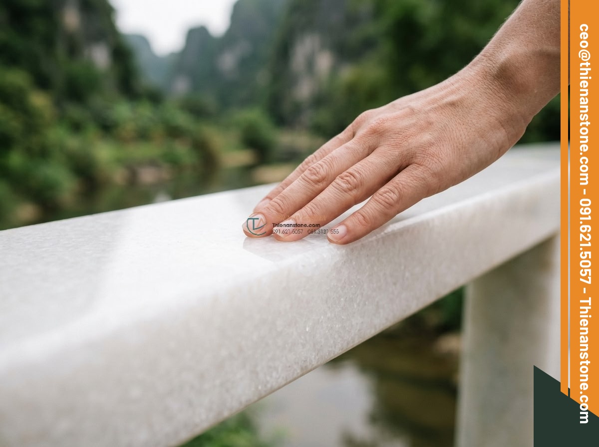 Cầu phiến phẳng đá trắng muối mài bóng bề mặt: 200 x 85 x 20 cm. - Hình 3 Cầu phiến phẳng đá trắng muối mài bóng bề mặt: 200 x 85 x 20 cm. - Intimate close-up of a hand gently touching the mirror-polished white salt stone
