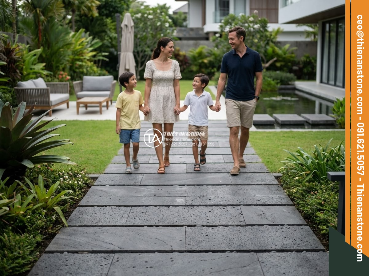 Đá Bazan Khò Mặt Chữ Nhật Bước Dạo - Chất liệu: Đá bazan tự nhiên - Kích thước: 40x60cm, dày 3-4cm (viền chìa hoặc thẳng) - Hình 16 Đá Bazan Khò Mặt Chữ Nhật Bước Dạo - Chất liệu: Đá bazan tự nhiên - Kích thước: 40x60cm, dày 3-4cm (viền chìa hoặc thẳng) - Happy family walking on newly installed basalt stone path in their luxury villa
