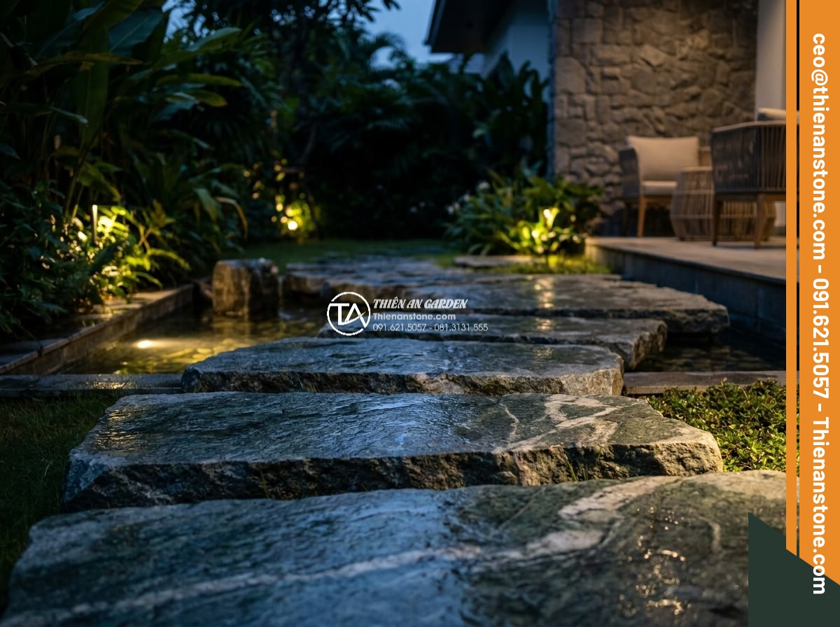 Đá Cuội Xanh Thanh Hóa Bước Dạo - Chất liệu: Đá cuội xanh tự nhiên (Thanh Hóa) - Kích thước: 35-100cm tự do (cắt từ viên cuội lớn), dày 4-5cm - Hình 10 Đá Cuội Xanh Thanh Hóa Bước Dạo - Chất liệu: Đá cuội xanh tự nhiên (Thanh Hóa) - Kích thước: 35-100cm tự do (cắt từ viên cuội lớn), dày 4-5cm - Evening garden lighting highlighting reflective green tones on Thanh Hoa pebble