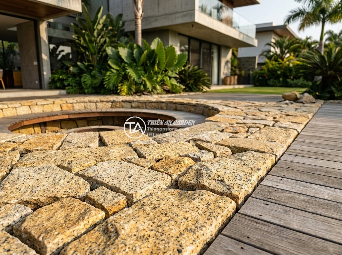 Đá Rối Granite Vàng Băm - Chất liệu: Đá granite vàng tự nhiên - Kích thước: Tự do 10-30cm/viên, dày 2-3cm (bề mặt băm nhám) - Hình 11 Đá Rối Granite Vàng Băm - Chất liệu: Đá granite vàng tự nhiên - Kích thước: Tự do 10-30cm/viên, dày 2-3cm (bề mặt băm nhám) - Modern luxury villa backyard with elegant arrangement of yellow granite tumbled