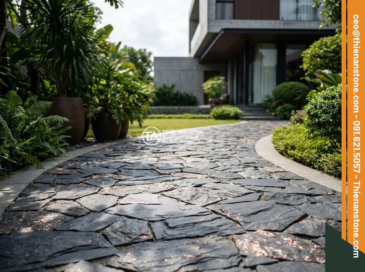 Đá Rối Slate Đen Vảy Đồng Lai Châu - Chất liệu: Đá slate đen vảy đồng tự nhiên (Lai Châu) - Kích thước: Ngẫu nhiên 10-25cm/viên, dày 1.5-3cm - Hình 9 Đá Rối Slate Đen Vảy Đồng Lai Châu - Chất liệu: Đá slate đen vảy đồng tự nhiên (Lai Châu) - Kích thước: Ngẫu nhiên 10-25cm/viên, dày 1.5-3cm - Curved elegant pathway in luxury Vietnamese villa garden paved with irregular bl