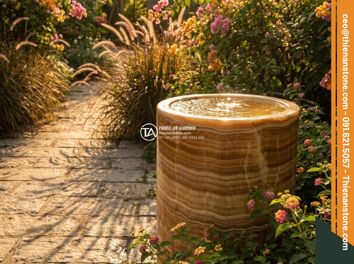 Lavabo đá vân gỗ hình trụ nông cao 15cm (400x400x150mm) - Hình 9 Lavabo đá vân gỗ hình trụ nông cao 15cm (400x400x150mm) - Dramatic golden hour lighting on the cylindrical natural stone lavabo with wood