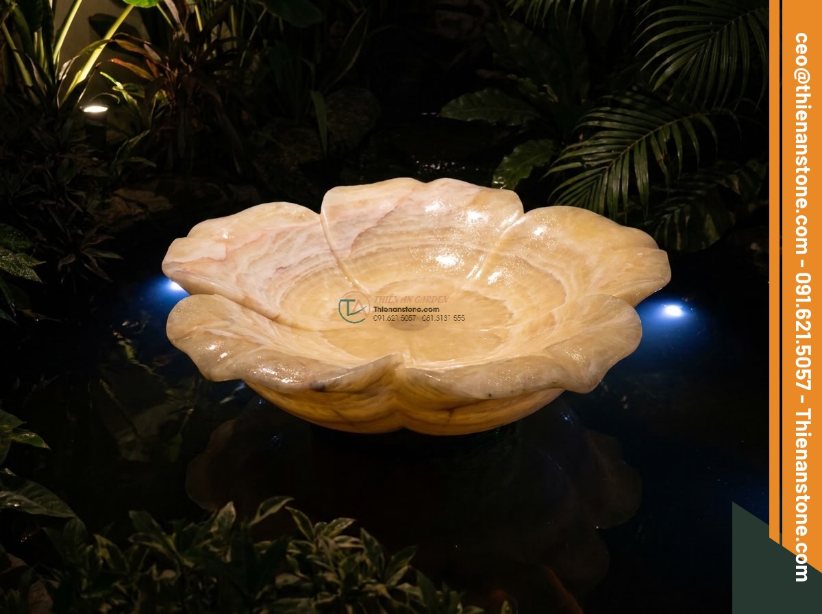 Lavabo đá vàng cà rốt hình bông hoa (400x400x150mm) - Hình 8 Lavabo đá vàng cà rốt hình bông hoa (400x400x150mm) - Nighttime scene of the yellow carrot stone flower lavabo lit by warm garden spot