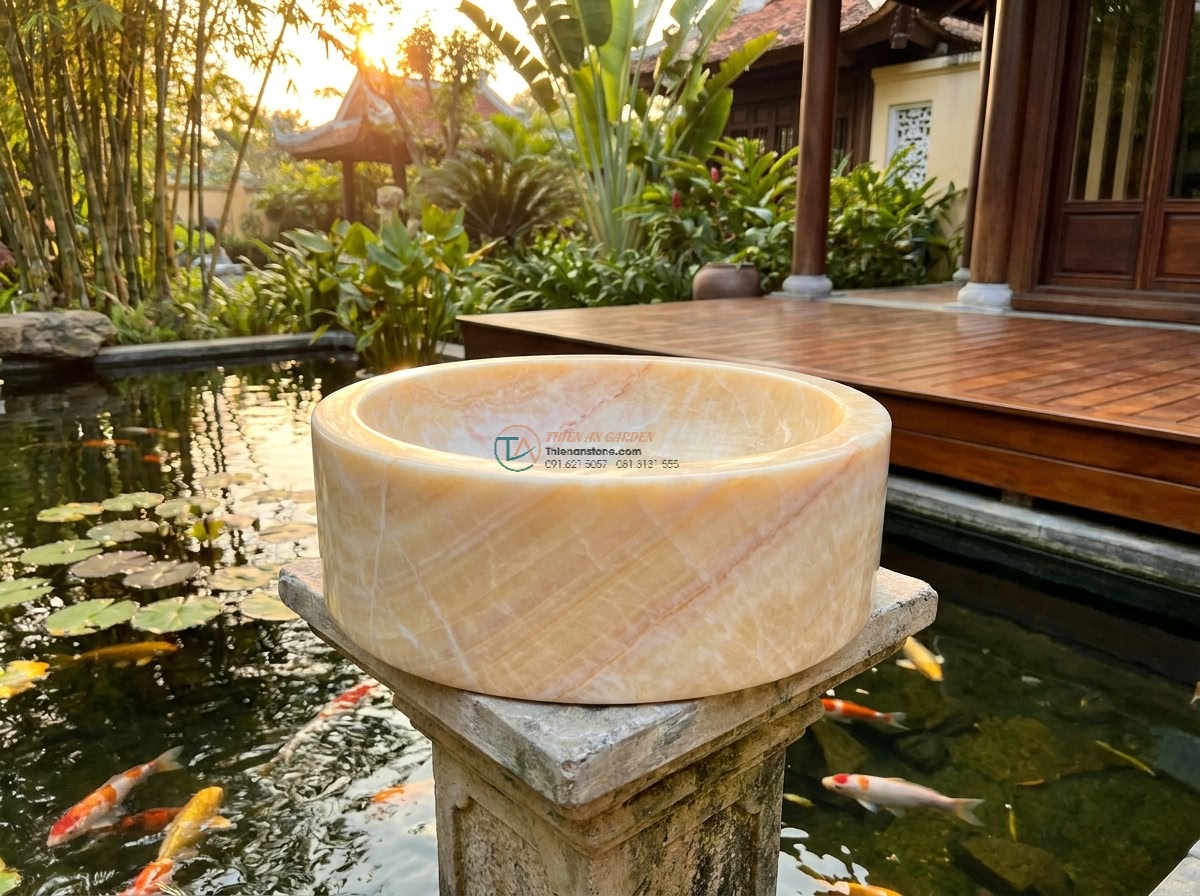 Lavabo đá vàng cà rốt hình trụ nông cao 15cm (400x400x150mm) - Photorealistic luxury outdoor garden scene at golden hour, a shallow cylindrical