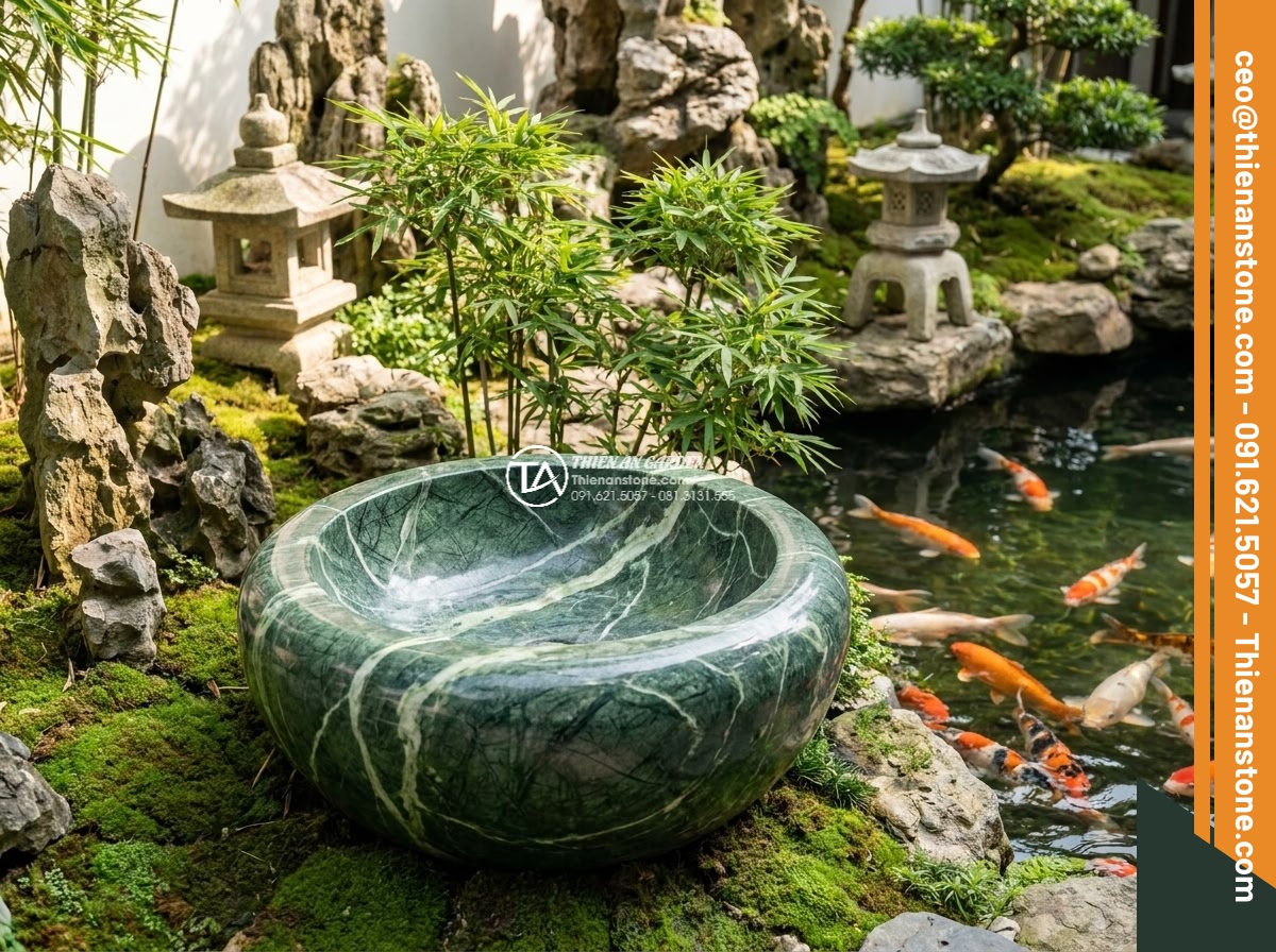 Lavabo đá xanh Ấn độ hình trụ nông cao 15cm - Hình 13 Lavabo đá xanh Ấn độ hình trụ nông cao 15cm - Serene scene of the Indian green stone lavabo positioned next to a Koi pond with