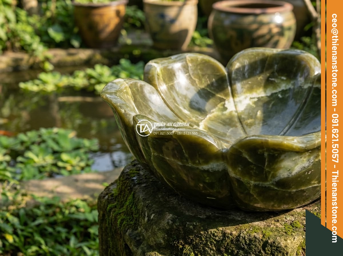 Lavabo đá xanh Ngọc Secpentine hình bông hoa (400x400x150mm) - Hình 2 Lavabo đá xanh Ngọc Secpentine hình bông hoa (400x400x150mm) - Close-up angled view of the flower-shaped green serpentine lavabo showing intric