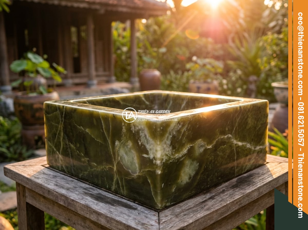 Lavabo đá xanh Ngọc Secpentine vuông 42cm (420x420x150mm) - Hình 5 Lavabo đá xanh Ngọc Secpentine vuông 42cm (420x420x150mm) - Golden hour cinematic scene of the square green serpentine lavabo in a resort ga