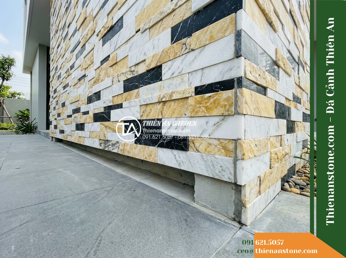 Đá ghép 3 màu Nghệ An | Marble phối 3 màu (Trắng - Vàng - Đen Nghệ An) | 10x50 cm - Hình 10 Đá ghép 3 màu Nghệ An | Marble phối 3 màu (Trắng - Vàng - Đen Nghệ An) | 10x50 cm - A wide-angle construction shot showcasing the base of an exterior feature wall a