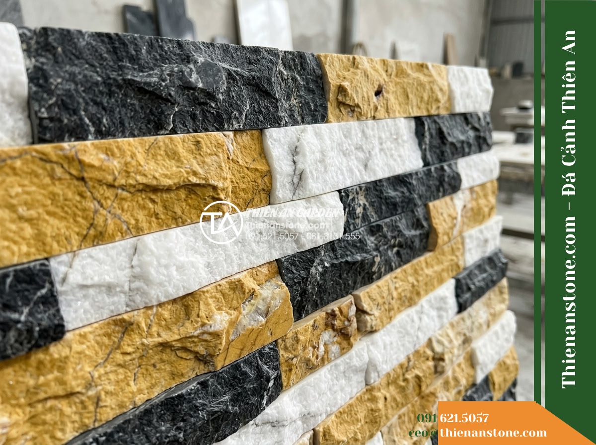 Đá ghép 3 màu Nghệ An | Marble phối 3 màu (Trắng - Vàng - Đen Nghệ An) | 10x50 cm - Hình 4 Đá ghép 3 màu Nghệ An | Marble phối 3 màu (Trắng - Vàng - Đen Nghệ An) | 10x50 cm - A detailed angled shot displaying the tactile interface between rough fractured